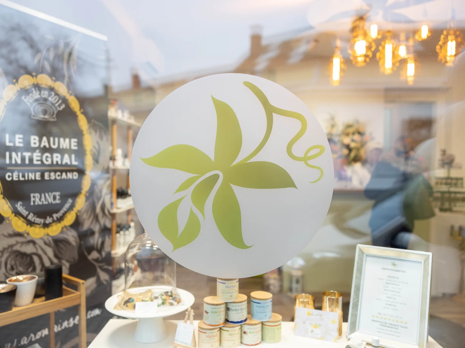 Schaufenster der Aromainsel mit der Blüte des Aromainsel-Logos als Fensterfolie