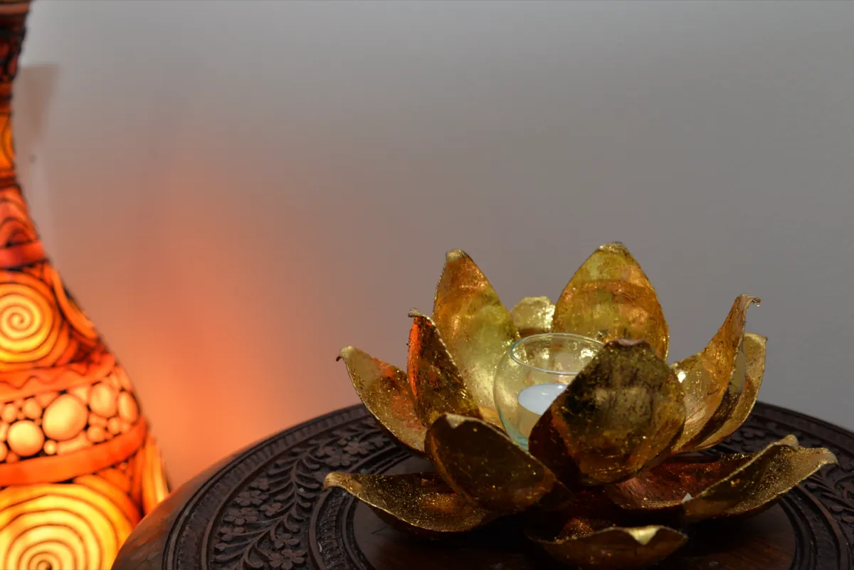 Goldene Lotus-Kerzenhalterung mit brennender Kerze